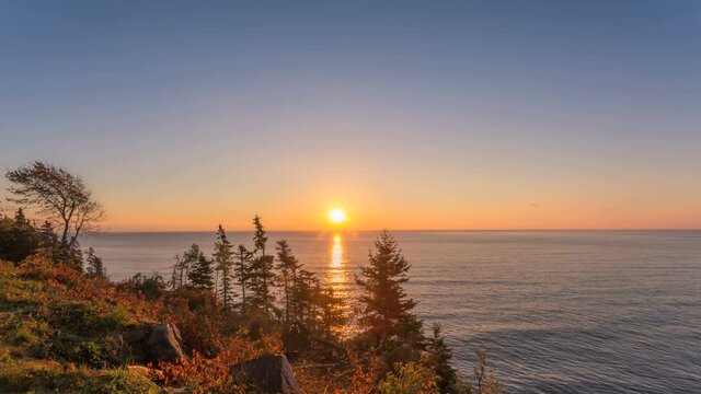 A glorious sunrise on the Ingonish Beach, shores of Atlantic ocean, Cape Breton Island, Canada. A Timelapse.