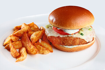 Burger with breaded chicken cutlet on a white plate. Copy of the space.