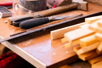 Joiner tools on a workbench, wood carving. The process of creating furniture, all in sawdust and dust. Hammer, scissors, leneka, wooden bars, blanks