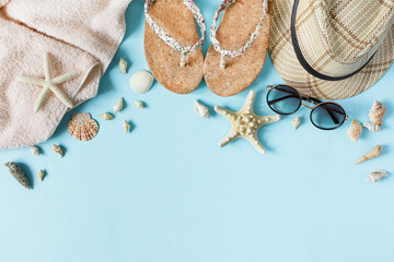 Beach accessories on pastel blue background top view. Summer background.