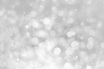 White glitter vintage lights background. White bokeh on black background.