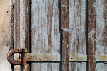 Wooden door of an old barn with rusty hinges