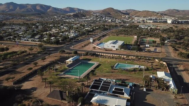 4K aerial drone video of public swimming pool in Olympia suburb and view of distant mountains in Namibia's capital in central highland Khomas Hochland of Namibia, southern Africa