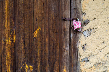 Wooden door of an old barn with rusty hinges and a padlock