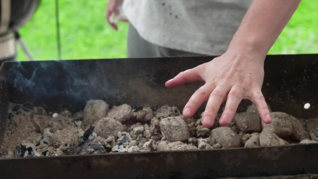A man cooks salmon on coals with garlic and herbs. 4K shooting