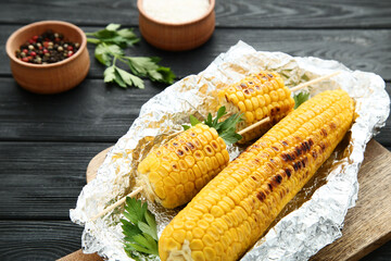 Grilled corn with green parsley on wooden table