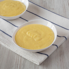 Homemade vanilla custard pudding in white bowls, low angle view.