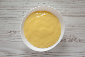Homemade vanilla custard pudding in a white bowl, top view. Flat lay, overhead, from above.