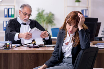 Old male judge and female client in the office
