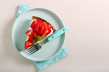 Slice of cheesecake with cream and strawberry topping