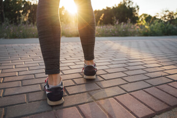 The girl runs from the side of the sunset on the path