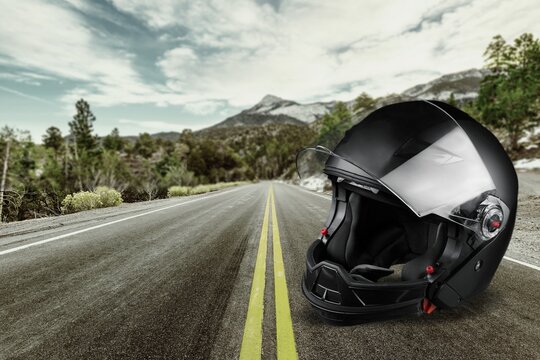 Motorcycle biker helmet on road background