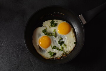 Two fried eggs in cast iron frying pan Healthy easy breakfast on a table. Fresh homemade meal on a frying pan. Traditional breakfast food. International cuisine food. Top view.