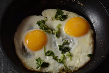 Two fried eggs in cast iron frying pan Healthy easy breakfast on a table. Fresh homemade meal on a frying pan. Traditional breakfast food. International cuisine food. Top view.