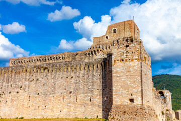La rocca Maggiore dell'Albornoz ad Assisi, Umbria, Italia, con cielo blu e nuvole bianche