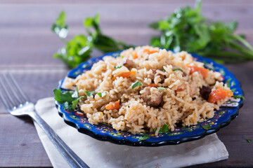Pilaf - traditional Eastern dish made with rice, vegetables and meat. Asian food. The concept of oriental cuisine , on a wooden table