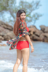 Cute young asian woman in bikini happy on beautiful beach in summer vacation in Thailand