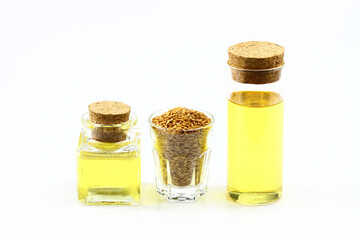 Flax seeds are in small glass and bottle of flaxseed oil on a white background.