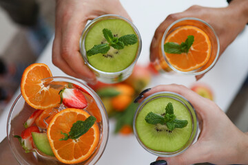People holding glasses with bright fruit drinks