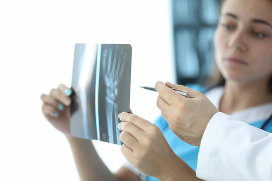 Woman looks at an x-ray hand, next to doctor