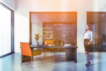 Woman in white CEO office with orange chairs
