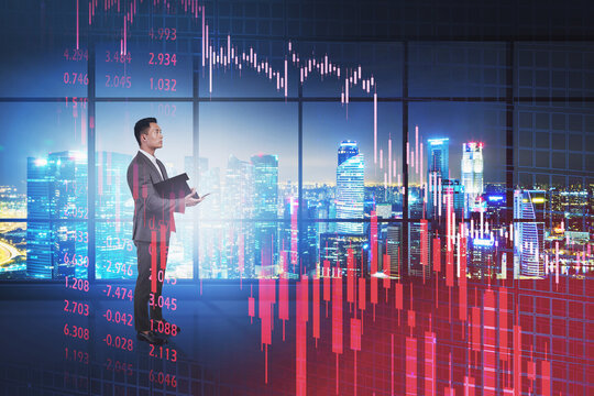 Asian man in night office, falling graph