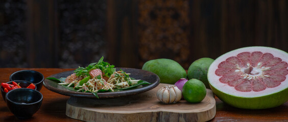 A spicy mango salad with vegetables, grapefruit or pomelo, mint leaves and chili.