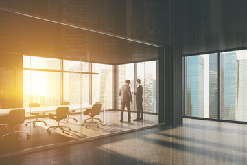 Businessmen in dark grey meeting room corner