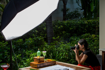 Young woman with professional camera taking food photo. Professional food photographer working on a set in restaurant