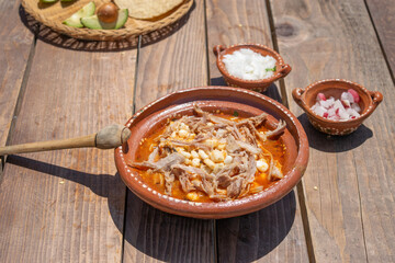 Mexican food dish. pozole with avocado and onion avocados,