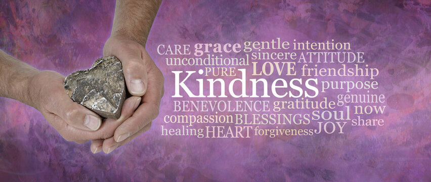 Heart felt Kindness Concept  Word Cloud - male hands gently cupped around a wooden heart beside a  Kindness word tag cloud against a wide rustic pink  grunge background
