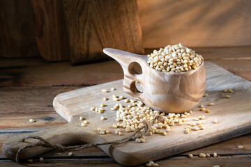 Cedar nuts in wooden pot on rustic background 