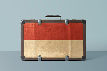 Indonesia flag on old vintage leather suitcase with national concept. Retro brown luggage with copy space text.