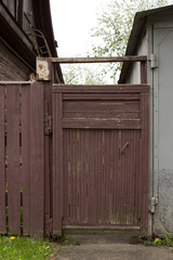 Wooden gate, entrance to a private house on a village street.