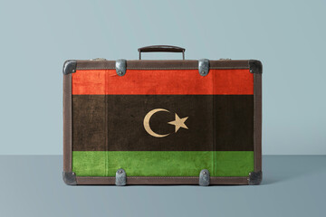 Libya flag on old vintage leather suitcase with national concept. Retro brown luggage with copy...