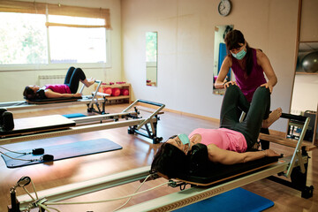 group of mature women doing excercise, Pilates and Yoga with social distancing and face mask