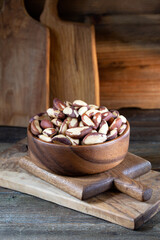 Brazil nuts in round bowl on wooden boards