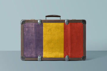 Romania flag on old vintage leather suitcase with national concept. Retro brown luggage with copy space text.