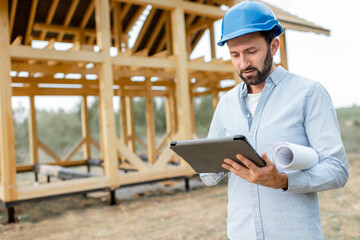 Architect or builder using digital touchpad on the construction site outdoors. Concept of building...
