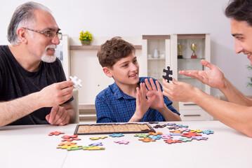 Three generations of family playing jigsaw puzzle game