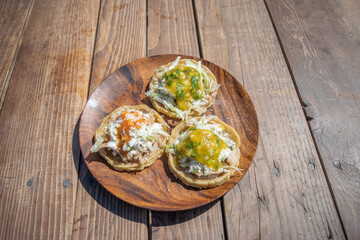 top view of mexican food dish with sopes with sauces