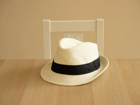 Accessories to wear during the summer. A simple straw hat on a table inside the home living room.