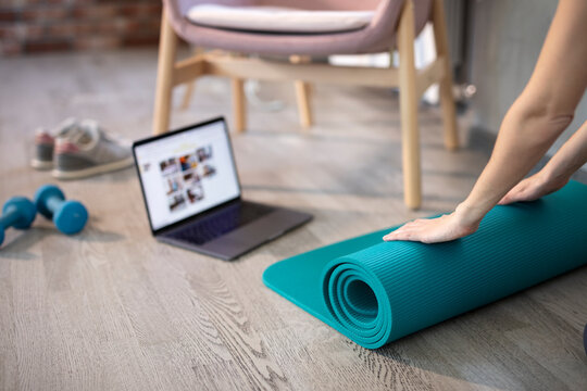 Young sporty slim woman preparing for online fitness training with modern laptop. Healthy lifestyle concept, online fitness and sport lessons. 