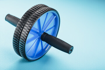 Blue roller for abs pumping classes on a blue fitness Mat.