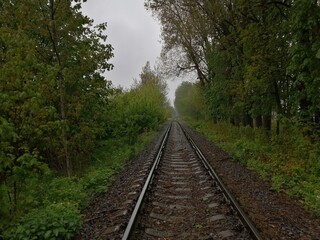 Fototapeta na wymiar sleepers rails railroad linear perspectives bottom view stones rubble trees