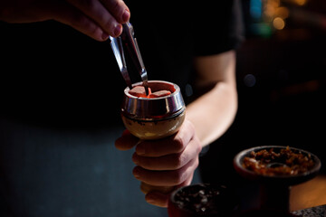 Shisha hookah with red hot coals. Modern hookah with coconut charcoal for relax and shisha smoke. Hookah and sparks from coals.