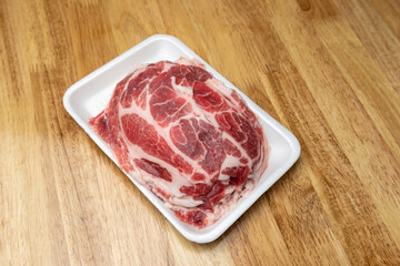 slice pork in tray foam on wooden board background