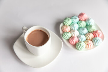 Obraz na płótnie Canvas Multicolored meringues and a cup of coffee on a white background. isolated