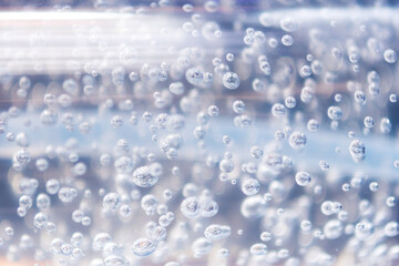 Transparent bubbles in the gel liquid. Light blue background with bubbles