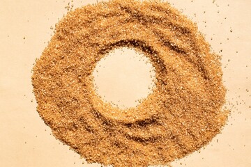 a circle of cane sugar on a beige background with space for an inscription